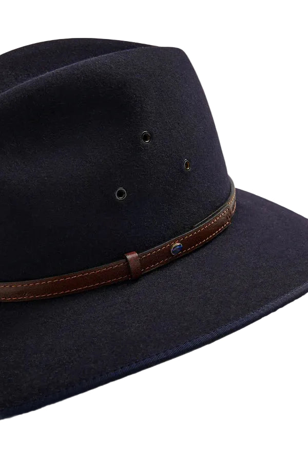 Navy blue hat with a brown leather band on a beige background